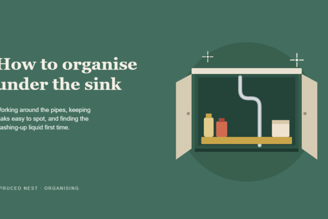 Organized cabinet showing under kitchen sink storage with bins and a caddy around the pipes